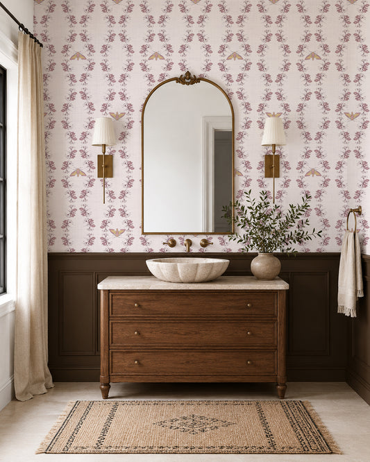 Night Bloom Soft Blush wallpaper in an elegant bathroom with dark wood vanity, brass accents and cream wainscoting.