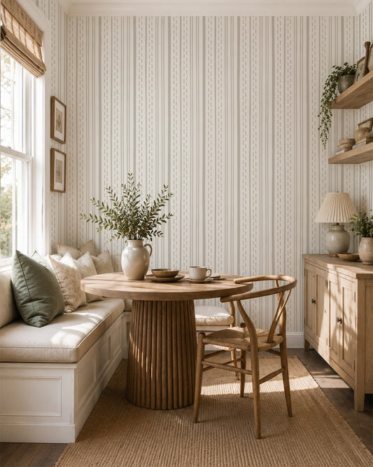 Ticking Stripe Soft Taupe on Cream wallpaper in a cozy dining nook with wood furniture and soft natural light.