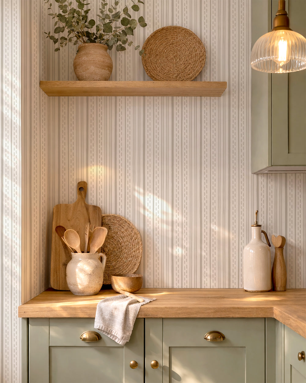Ticking Stripe Soft Taupe on Cream wallpaper in a warm kitchen with wood accents, cream pottery and natural light.